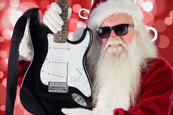 Santa claus in sunglasses holding guitar during christmas time
